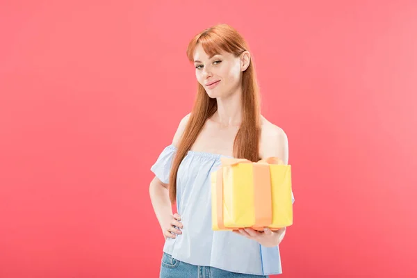ピンクに隔離されたリボンと黄色のギフトボックスを保持赤毛の誕生日の女の子 — ストック写真