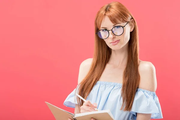 Mulher Ruiva Atraente Óculos Segurando Lápis Livro Didático Isolado Rosa — Fotografia de Stock