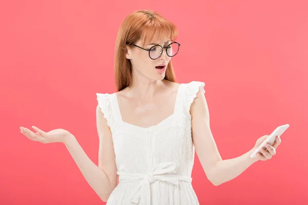 Mulher Ruiva Descontente Óculos Vestido Branco Usando Smartphone Isolado Rosa — Fotografia de Stock