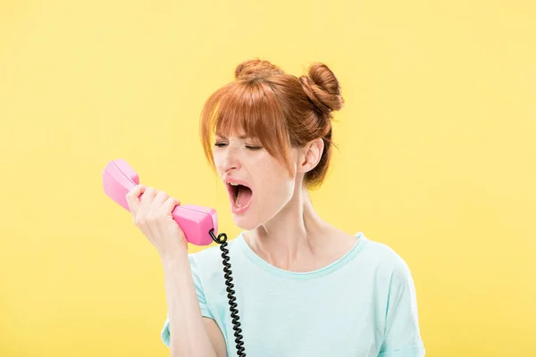 Estressado Ruiva Jovem Segurando Auscultador Gritando Isolado Amarelo — Fotografia de Stock