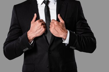 gri izole ceket elleri ile siyah takım elbiseli işadamı kırpılmış görünümü