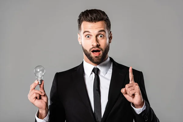 Shocked Businessman Black Suit Holding Light Bulb Showing Idea Gesture — Stock Photo, Image