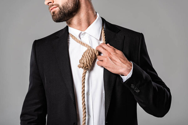 cropped view of depressed businessman in black suit with noose on neck isolated on grey