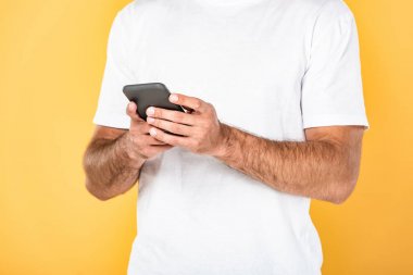 sarı izole akıllı telefon kullanarak beyaz t-shirt adam kırpılmış görünümü