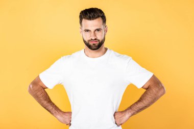 beyaz t-shirt gülümseyen yakışıklı adam sarı izole kalçaelleri ile