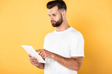sarı izole dijital tablet kullanarak beyaz t-shirt yakışıklı adam