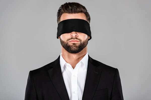 bearded handsome blindfolded businessman in black suit isolated on grey