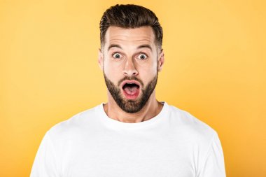 shocked handsome man in white t-shirt with open mouth isolated on yellow clipart