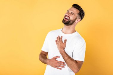 happy handsome man in white t-shirt laughing isolated on yellow clipart