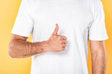 beyaz t-shirt adam kırpılmış görünümü sarı izole başparmak gösteren