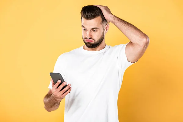 Homem Bonito Confuso Shirt Branca Usando Smartphone Isolado Amarelo — Fotografia de Stock