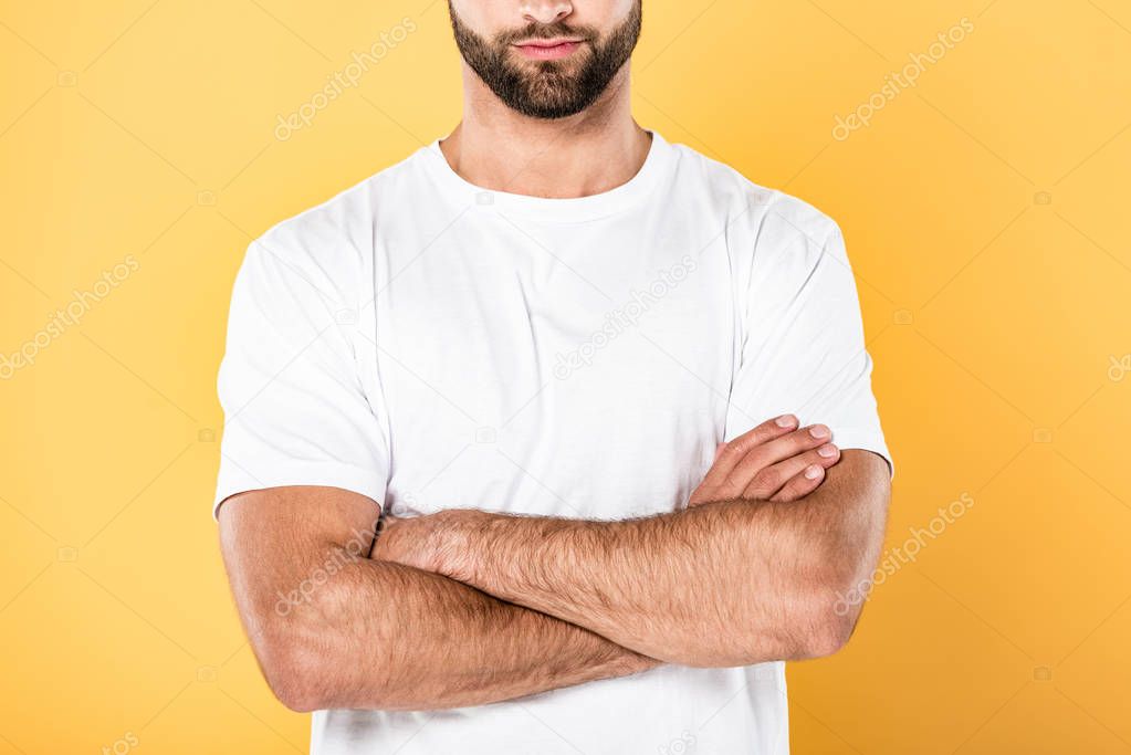 cropped view of man in white t-shirt with crossed arms isolated on yellow