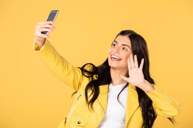 esmer kız sallayarak ve akıllı telefonda görüntülü sohbet, sarı izole
