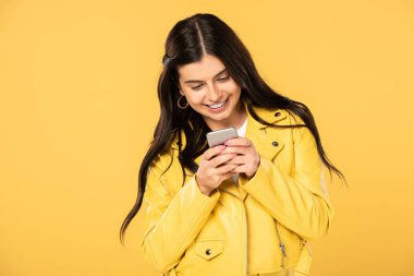 akıllı telefon kullanarak neşeli esmer kız, sarı izole