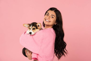 gülümseyen kız sevimli köpek yavrusu tutan, pembe izole