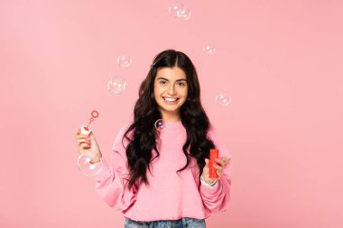 pembe izole sabun kabarcıkları üfleme mutlu güzel kız