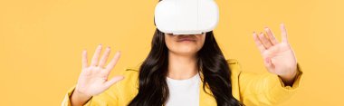 brunette woman using Virtual reality headset, Isolated On yellow