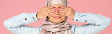 smiling muslim girl in hijab closing eyes, isolated on pink clipart