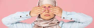 serious muslim girl in hijab closing eyes, isolated on pink clipart