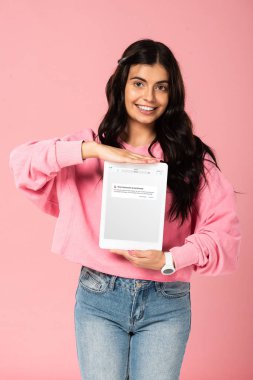 Kiev, Ukrayna - 30 Temmuz 2019: ekranda vk uygulaması ile dijital tablet tutan gülümseyen kız, pembe izole