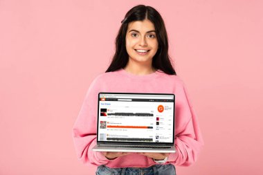 Kiev, Ukrayna - 30 Temmuz 2019: ekranda soundcloud web sitesi ile dizüstü bilgisayar tutan gülümseyen kız, pembe izole