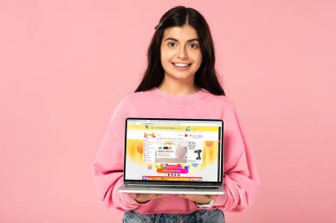 Kiev, Ukrayna - 30 Temmuz 2019: ekranda aliexpress web sitesi ile dizüstü bilgisayar tutan gülümseyen kız, pembe izole
