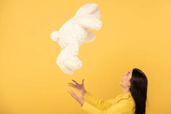Happy Girl Throwing Teddy Bear Isolated Yellow — Stock Photo, Image
