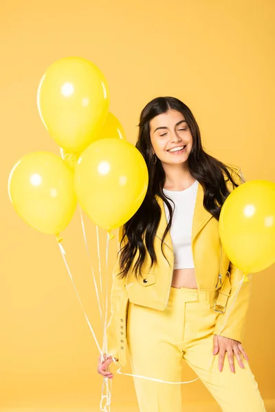 Mujer Alegre Sosteniendo Globos Amarillos Aislado Amarillo —  Fotos de Stock