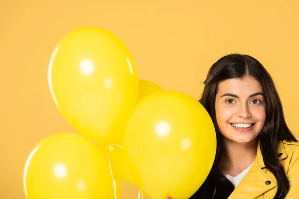 黄色の風船を持つ魅力的な笑顔の女の子 黄色に隔離 — ストック写真