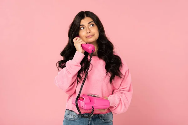 Peinzende Brunette Meisje Praten Retro Telefoon Geïsoleerd Roze — Stockfoto