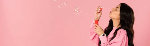 ピンクに隔離された石鹸の泡を吹く面白い女の子 — ストック写真