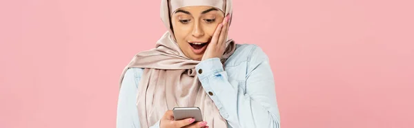 Megdöbbentett Muzulmán Lány Hidzsáb Segítségével Okostelefon Elszigetelt Rózsaszín — Stock Fotó