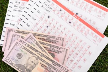 Dolar banknotları ve yeşil çimenler üzerine bahis listeleri, spor bahisleri konsepti