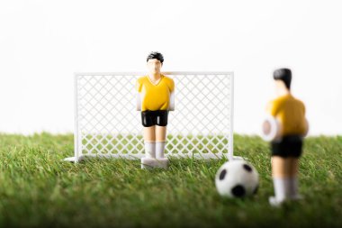 selective focus of toy football players, gates and ball on green grass isolated on white, sports betting concept clipart
