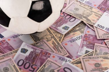 Futbol topuna Avro ve dolar banknotları, spor bahisleri konsepti