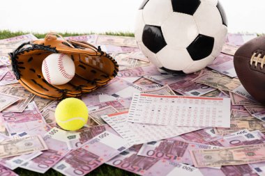 baseball glove and ball, soccer, tennis and rugby balls near betting lists on euro and dollar banknotes isolated on white, sports betting concept clipart