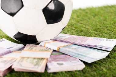 selective focus of euro and dollar banknotes near soccer ball on green grass, isolated on white, sports betting concept clipart