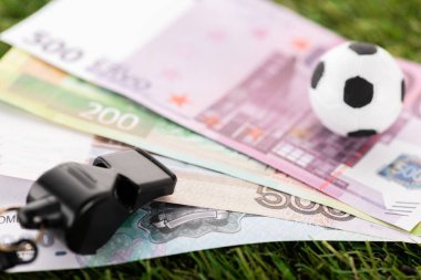 ıslık çalma, futbol topu ve yeşil çimlere Avro banknotları, spor bahisleri konsepti