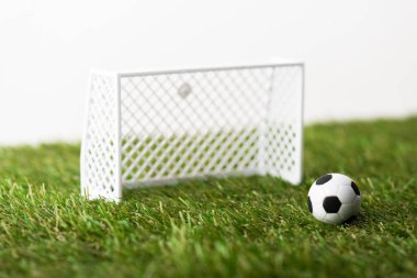 Oyuncak futbol kapıları ve top yeşil çimlerde izole edilmiş beyazlar, spor bahisleri konsepti
