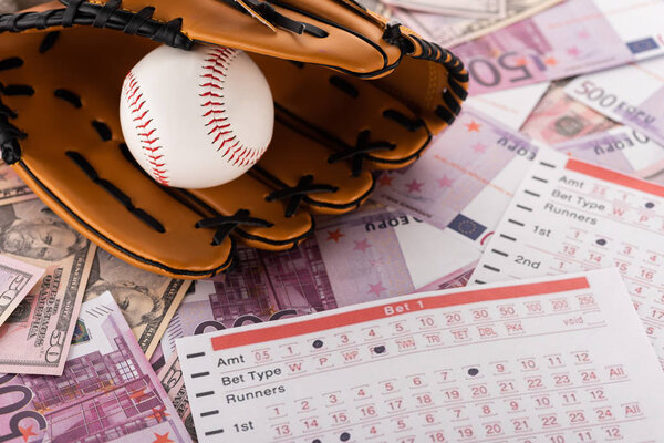 baseball glove and ball near betting lists on euro and dollar banknotes, sports betting concept