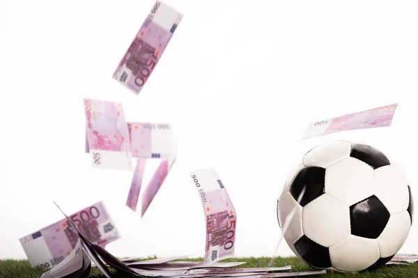soccer ball near flying euro banknotes isolated on white, sports betting concept