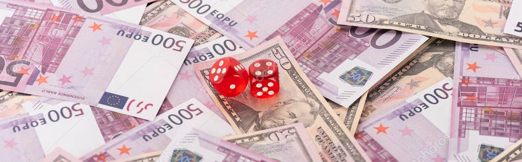 Panoramic shot of dice on euro and dollar banknotes, sports betting concept