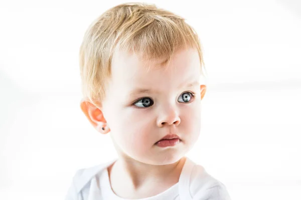 Bebê sonhador bonito com cabelo loiro olhando para longe isolado no branco — Fotografia de Stock