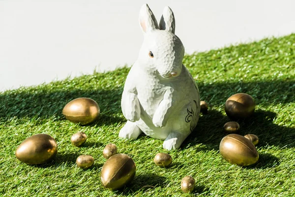 Декоративний Великодній кролик кінець блискучі золоті яйця ізольовані на сірому — стокове фото