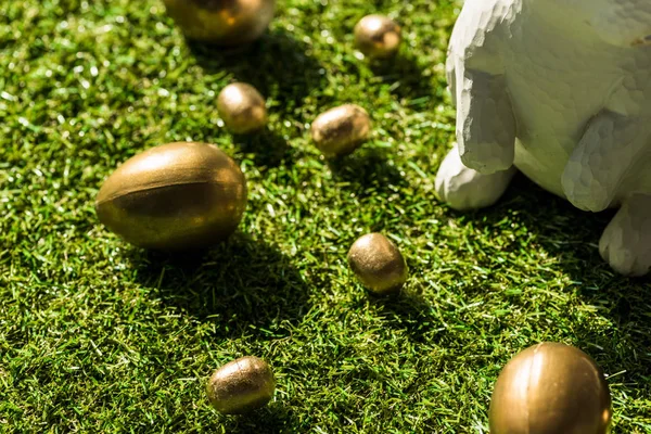 Shiny Easter eggs and decorative rabbit on green grass surface — Stock Photo