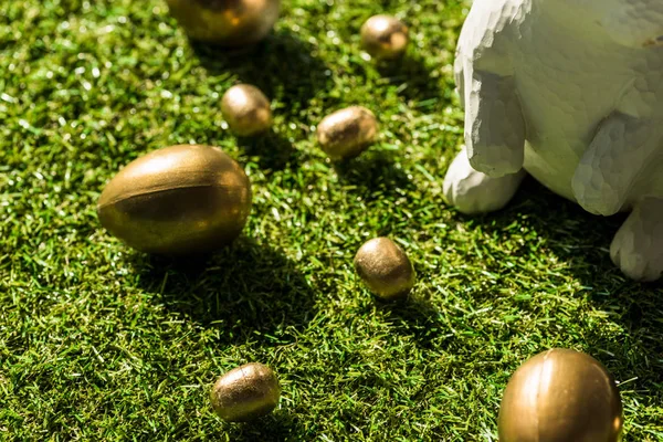 Glänzende Ostereier und dekorativer Hase auf grünem Gras — Stockfoto