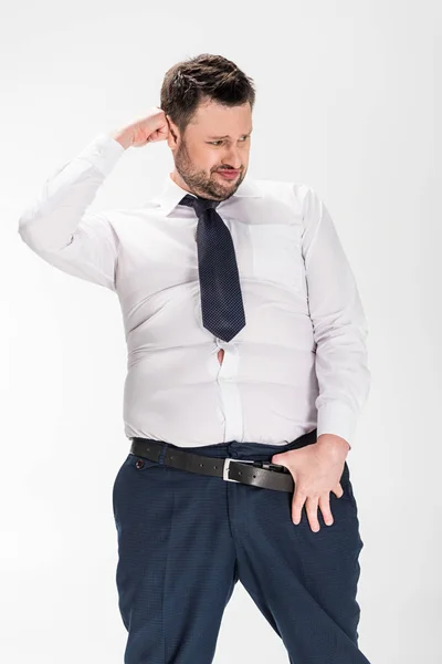 Homem com sobrepeso em apertado desgaste formal com a mão no cinto posando isolado no branco — Fotografia de Stock