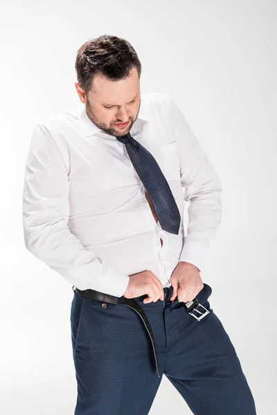 Надмірна вага людини в офіційному зносу покласти на жорсткі брюки на білому — стокове фото
