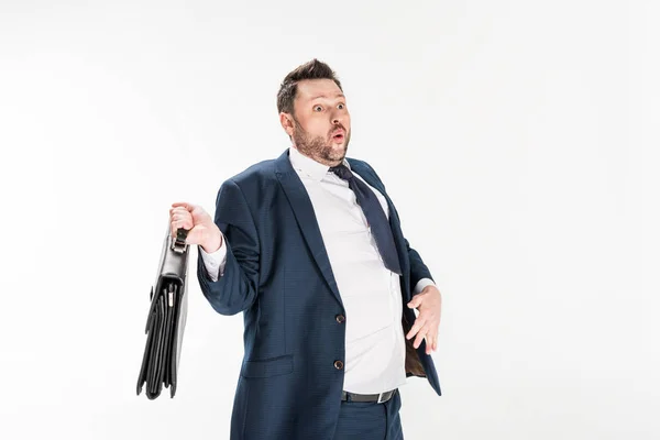 Surprised overweight businessman in tight formal wear holding briefcase isolated on white — Stock Photo