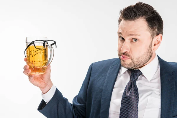 Gordito hombre en formal desgaste mirando a la cámara mientras sostiene el vaso de cerveza con gafas en aislado en blanco - foto de stock